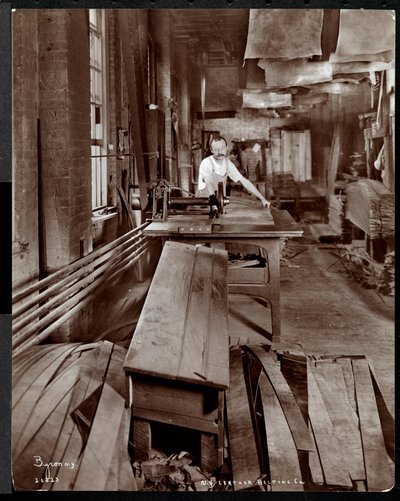 Vista interior de un hombre trabajando con cuero en la New York Leather Belting Co., Nueva York, 1905 de Byron Company